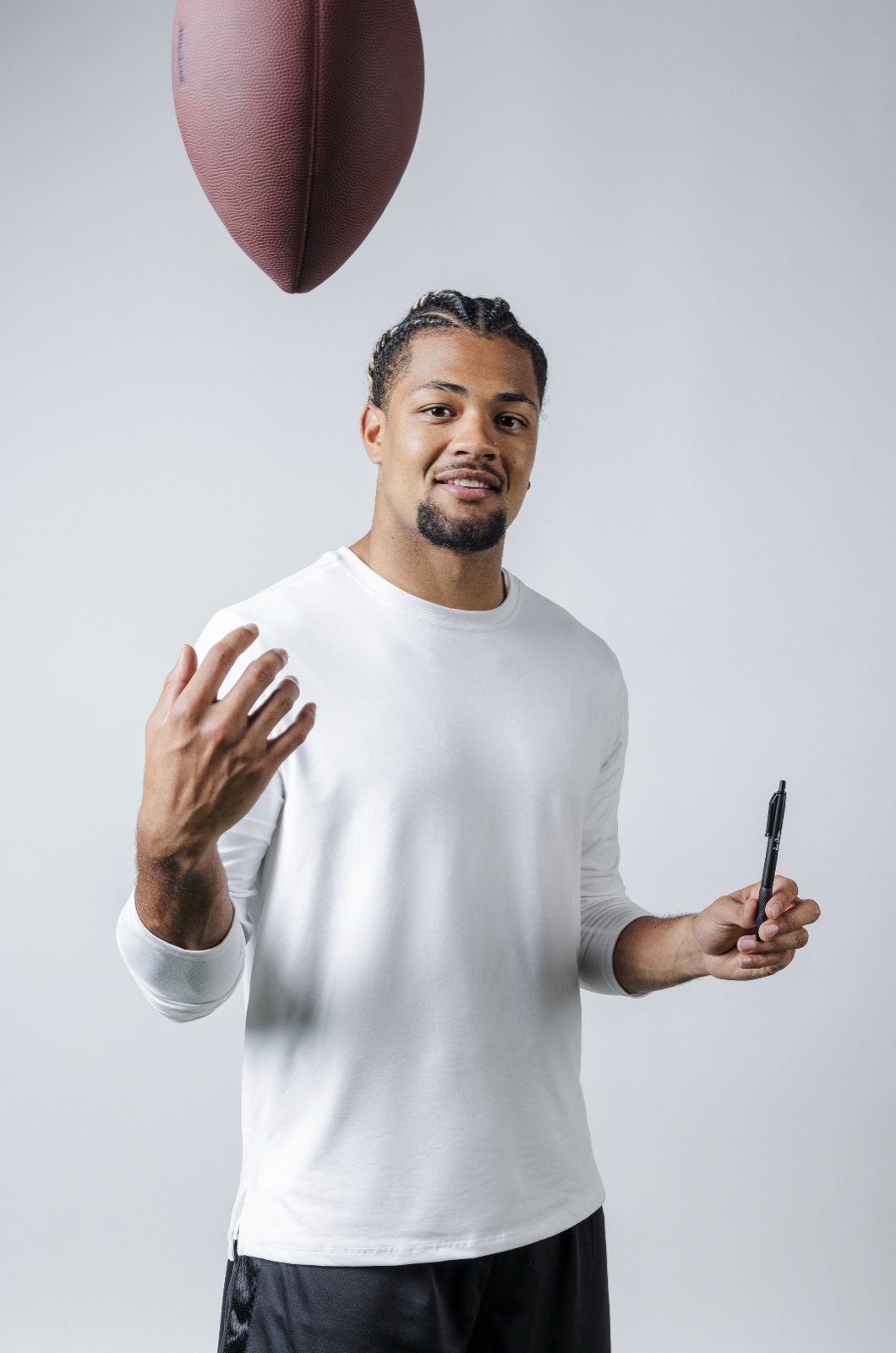 Athlete tossing a football with a Sharpie in hand