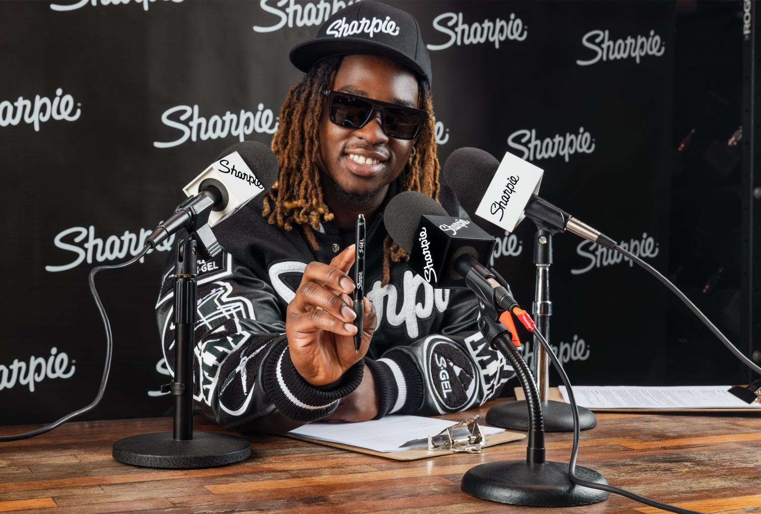 Athlete at the Sharpie press desk holding an S-Gel toward camera